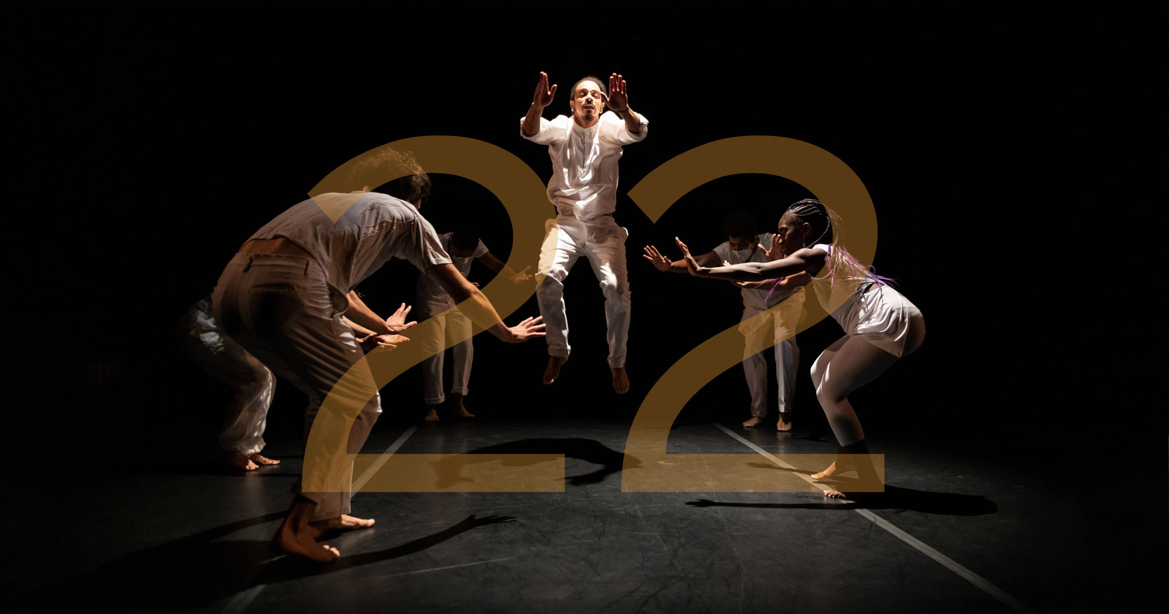 Union PDX - Festival:21 artist Rejoice! Diaspora Dance Theater performing a ring shout during their work 'Who We Carry' at the Hampton Opera Center in Portland, Oregon. The number 22 overlays the image to indicate the festival year. | Photography: Jingzi Zhao